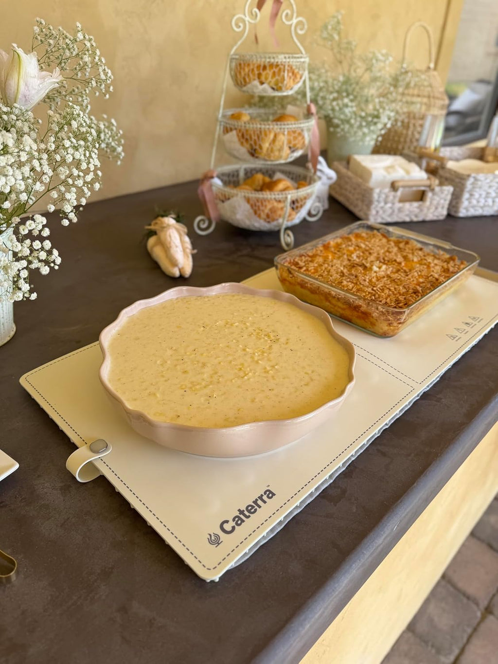 Cream Caterra warming mat keeping a pie dish and a baked casserole hot on a buffet table