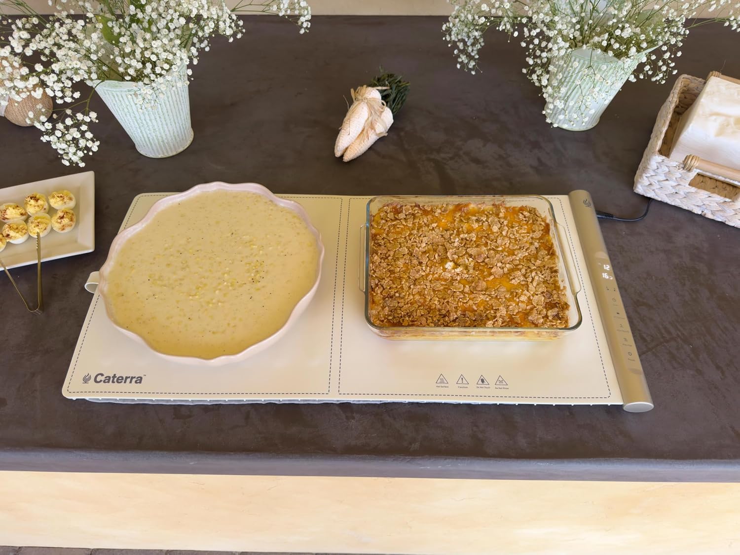 Overhead view of two dishes staying warm on the Caterra dual-zone warming mat at an outdoor buffet